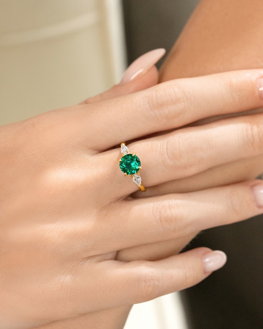 Tre-steins forlovelsesring med rund slipt smaragd i 18k gullforgylling